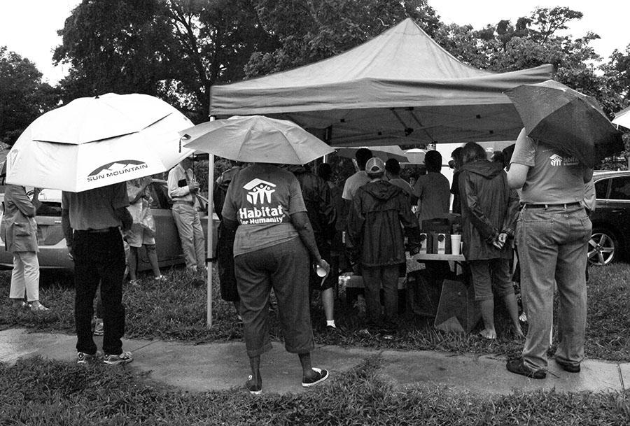 A group of dedicated volunteers huddled under a tent to avoid the rain