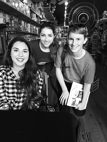 Freshmen Ava Hickman and Robby Witten smile with one of their favorite authors, Victoria Aveyard (left).