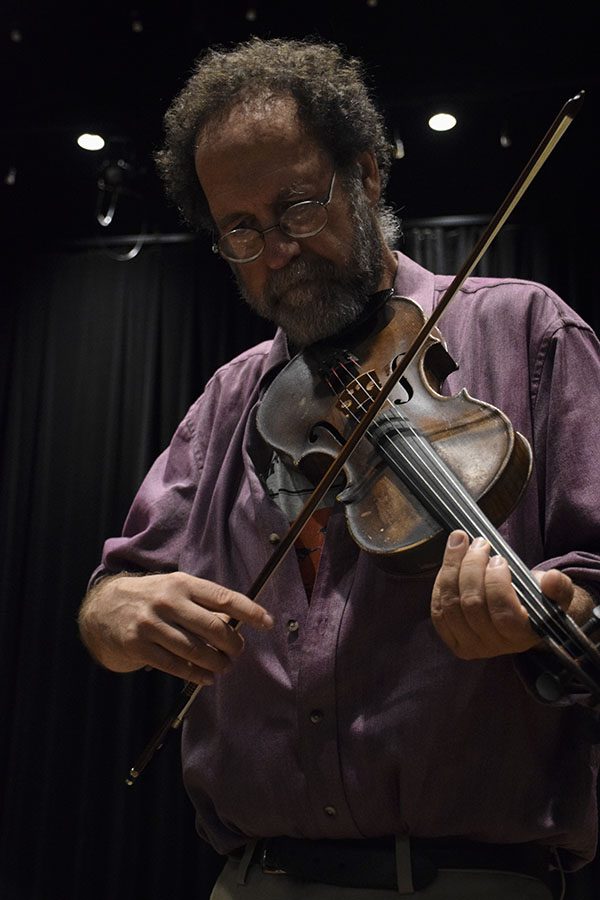Walkman plays his fiddle while performing his original poem Burnt Down House.