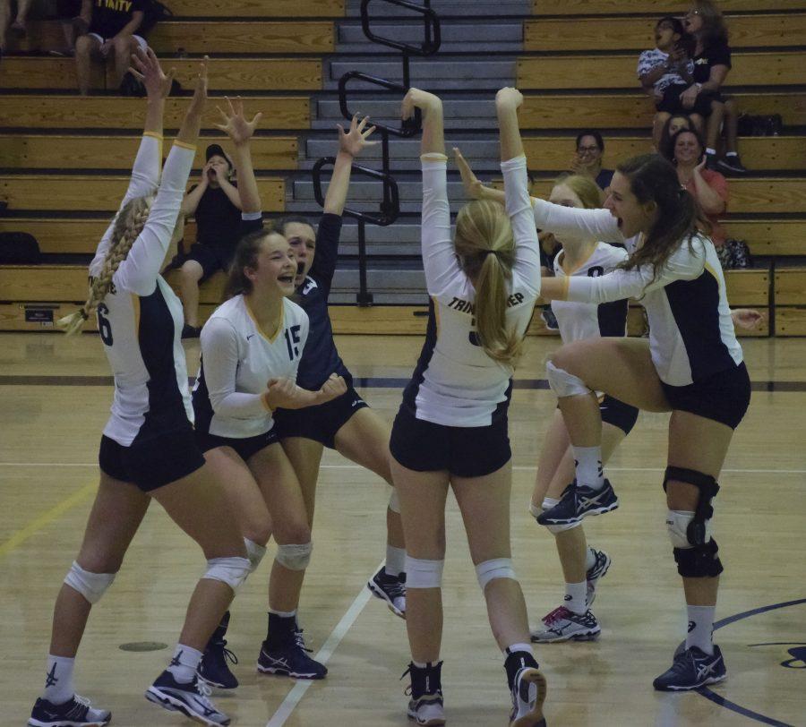The varsity volleyball team celebrates after a point.