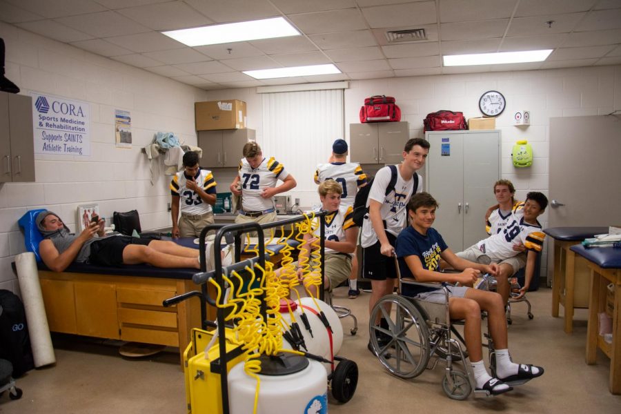 Members of the varsity football team hang out in the training room pregame.