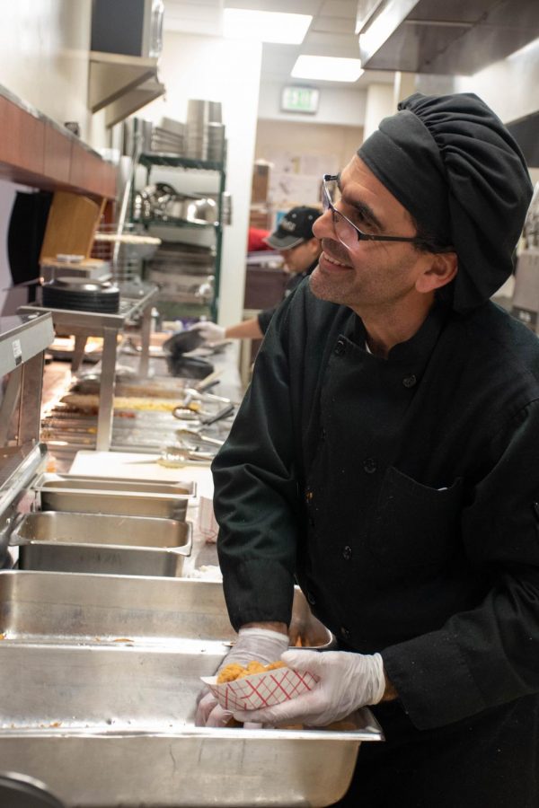 Chris serves up chicken tenders and smiles to students in the Grille during Upper School lunch. He said he appreciates the students and their friendly nature. 