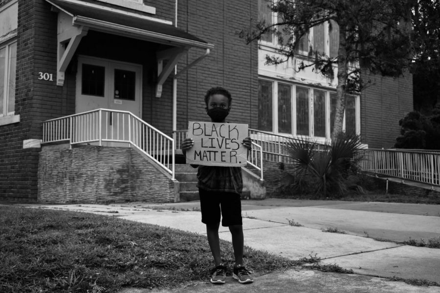 Adrian Beaupierre, a Sanford raised child, holds a sign supporting the Black Lives Matter movement. This movement impacts people of all ages, genders, and races in the fight for systematic equality.