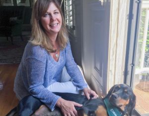 Librarian Lee De Groft pets her black and tan coonhound Brodie.