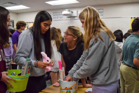 Eighth graders Faith Walsh, Brooke Kalmanson, Maiori Butz and Katie Alvarez make 
Easter baskets to donate through the Hoppy Easter fundraiser run by Builders Club.