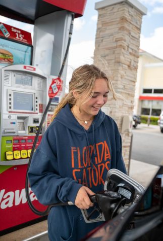 Senior Kelsey Silberbusch fills up her gas tank, which she says has gotten increasingly expensive with the recent rise in gas prices.