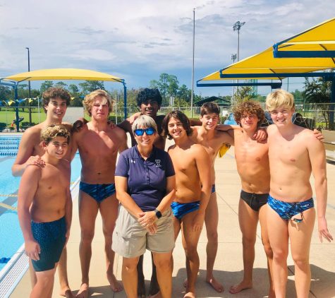 New Director of Aquatics Anne Marie Stricklin stands with part of the boys varsity swim team during an after-school practice. 