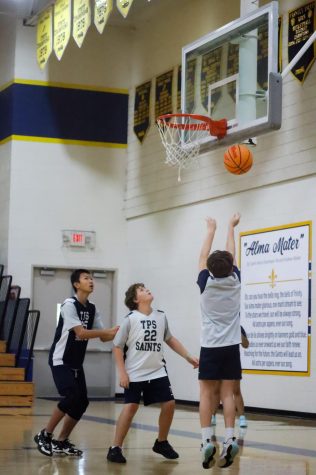 Boen Dong (left) and Carson Wiener (middle) watch on as Dylan Clark (right) finishes a layup. The three are a part
of the competitive 6th and 7th grade team, who practice separately from the newly formed developmental team.