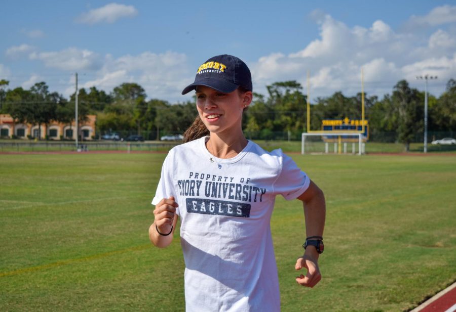 Senior Cross Country runner, Morgan Cox running on the track. She is wearing her Emory University gear where she plans
to run in college.