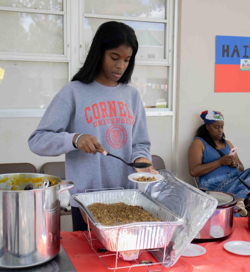Junior Amanda Toussaint serves food at the booth featuring Haiti.