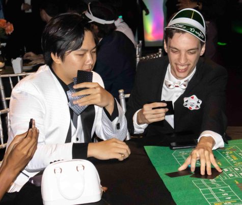 Senior Seth Brunner and junior Tony Ding, dabble in an intense game of cards. Given that the prom theme was casino, each table received a pack of black playing cards 