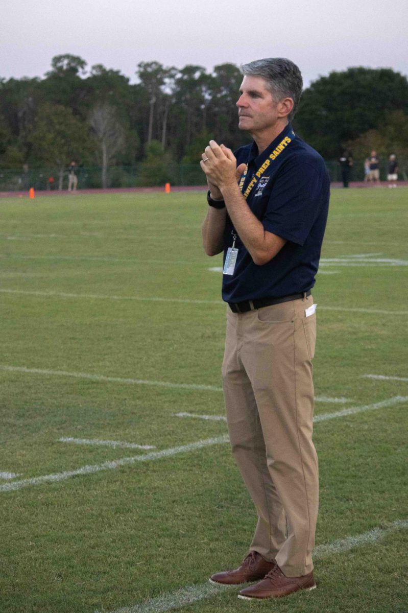 New Director of Athletics Colin Sullivan cheers on the football team as they play against Taylor High School (THS) on August 25. The final score was 6-44 in favor of THS.