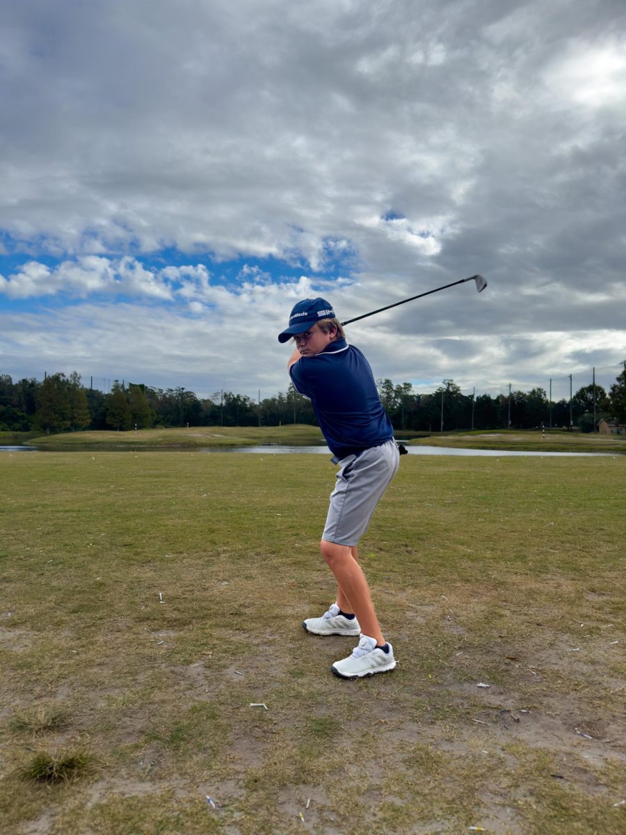 8th grader Ty Bogey prepares to swing his club while practicing at his local golf course.