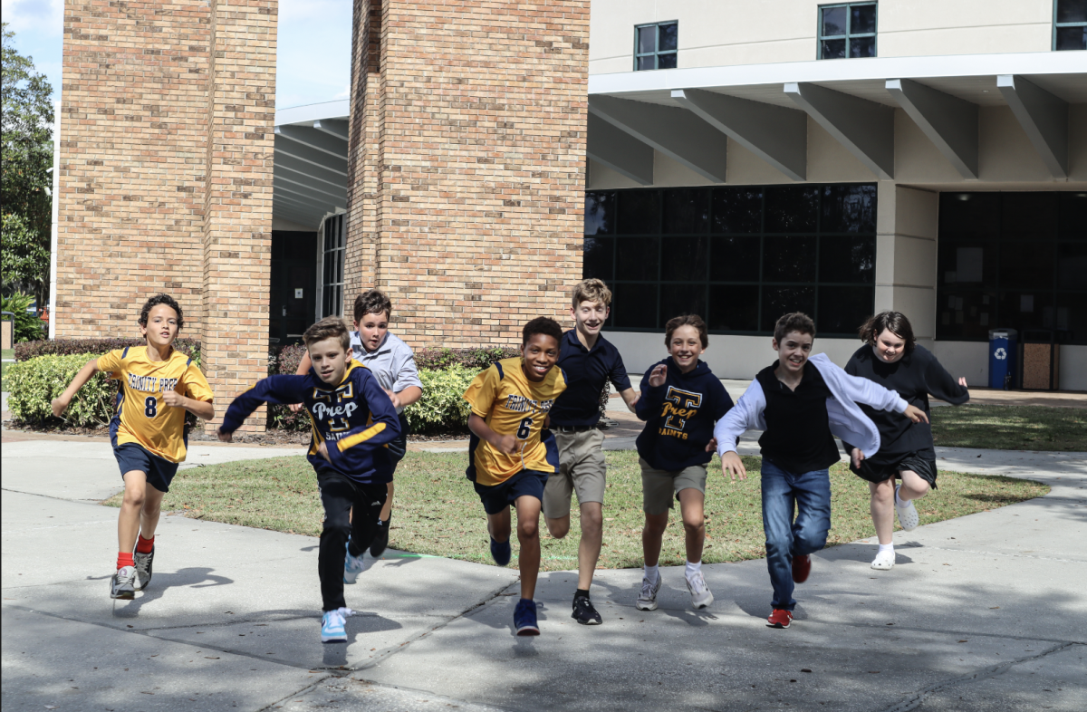 Middle schoolers run past the library while wearing Trinity Prep merchandise during Friday Spirit Day. These dress down days were just added this year to increase school spirit.