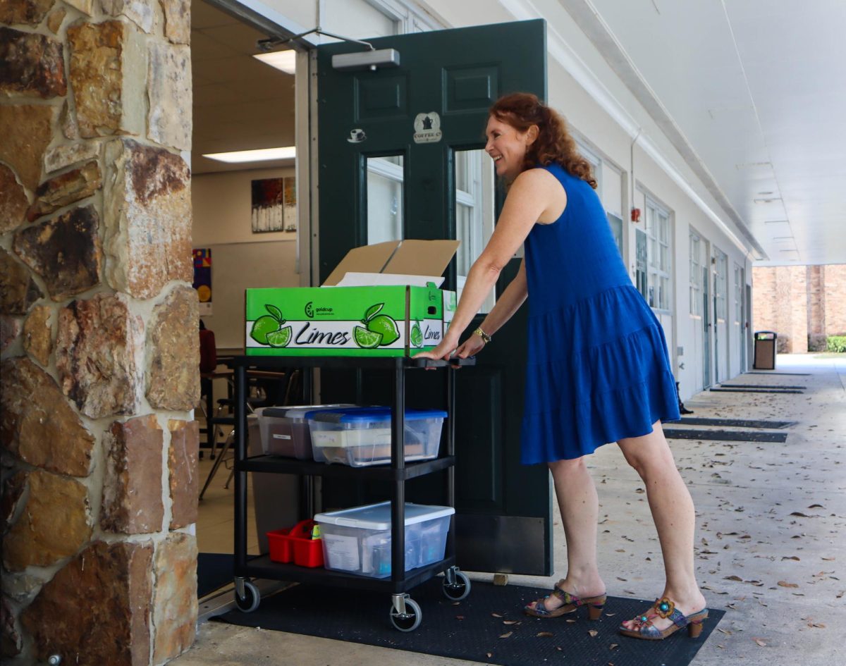 Dr. Elmarie Mortimer, one of the teachers affected from Oct. 20 to Oct. 30 by the pipe burst, pushes a cart of class supplies into Ms. Faris’ classroom. 
