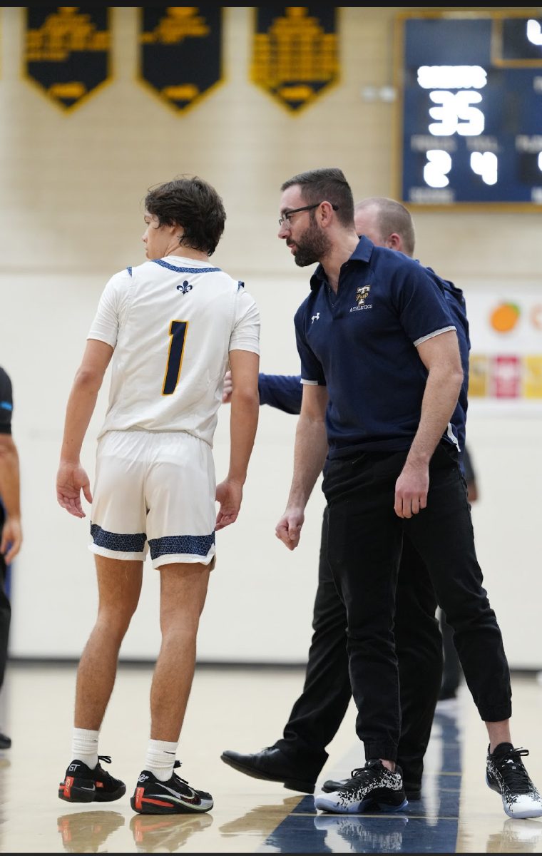 Mr. Palumbo, science teacher and basketball coach, coaching senior Jake Male from the sideline.  