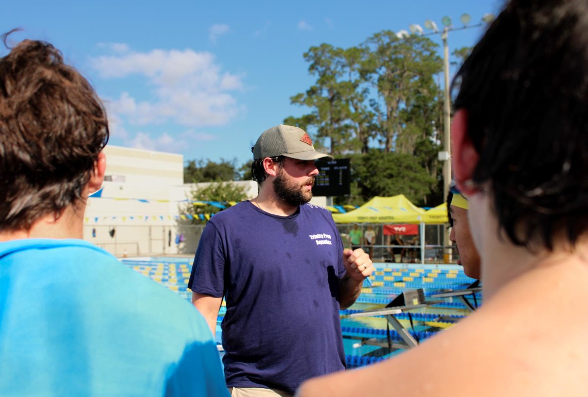 Head Coach Thomas Roark instructs the swim team on proper technique before a team practice.