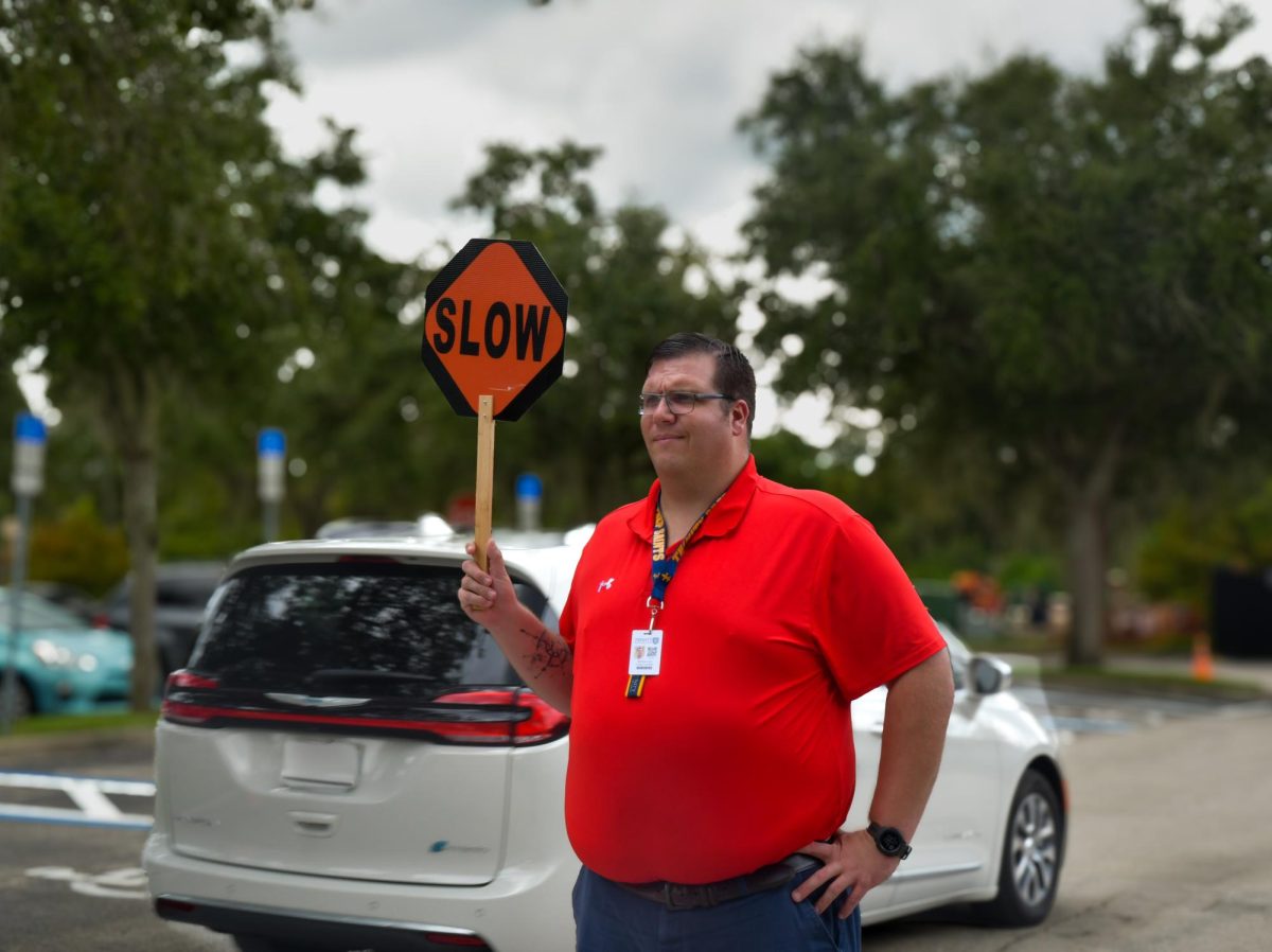 College counselor Matthew Likso provides speed reminders to parent and student drivers. The parking lot is just one of the many changes made this year.