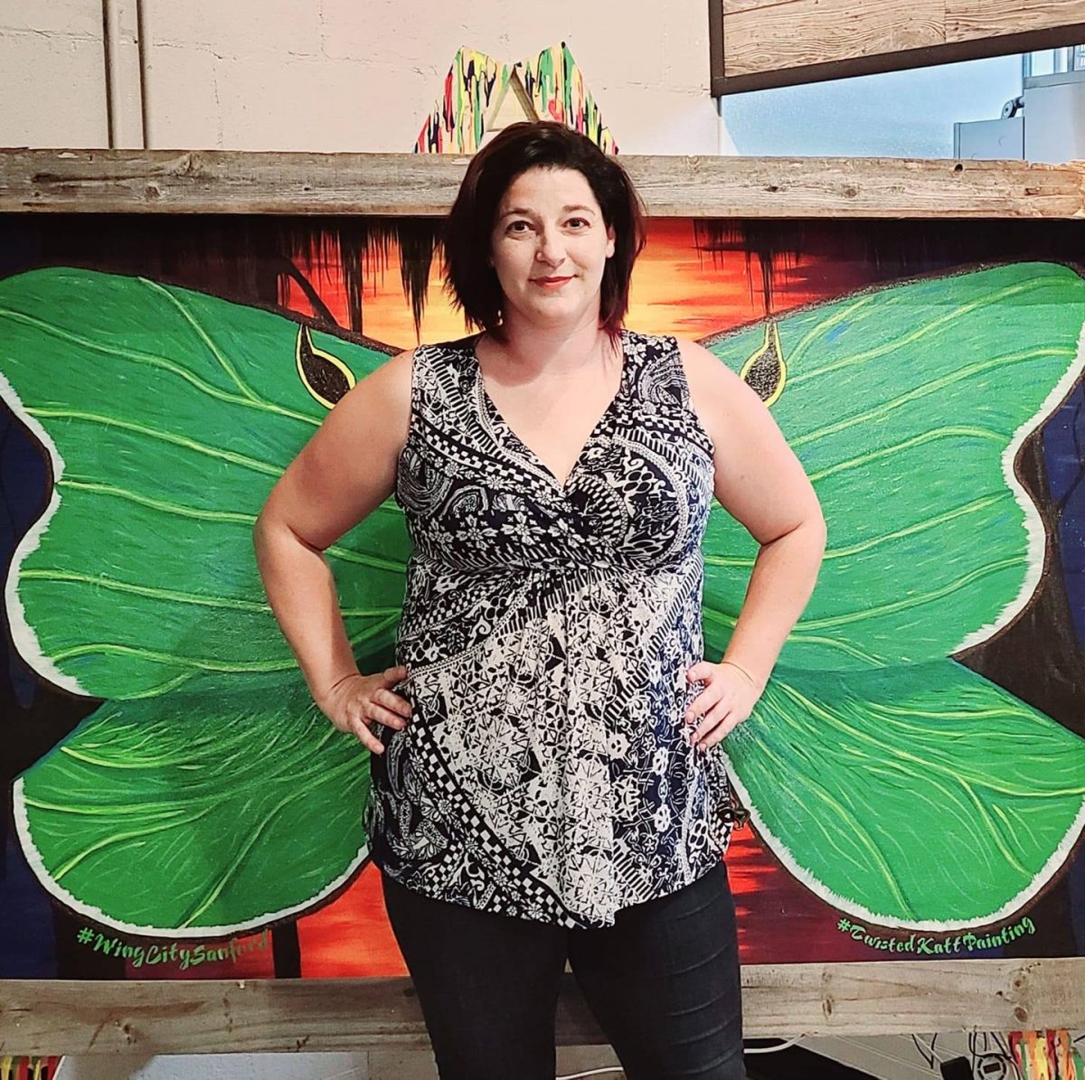 Catherine Kelly standing in front of her mural, which broke the world record for the largest mural art of wings. (Photo provided by Kelly)