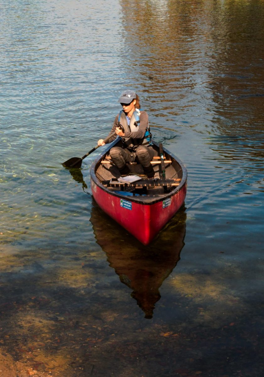 Berchem paddles slowly in the water, watching for manatees resting at Blue Spring State Park. 