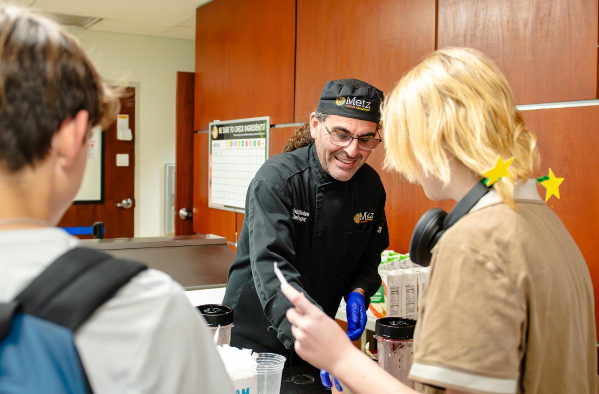 Chris Behrens, Chef Manager, serving smoothies to Trinity Prep students.