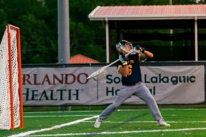 Dedicated athlete Olliver Polsinelli clears the ball during a varsity lacrosse game.