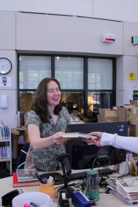 Library clerk Rachael Gryder checks out a book for a student. She is now moving to Tallahassee as her partner plans to attend a medical residency at Florida State.