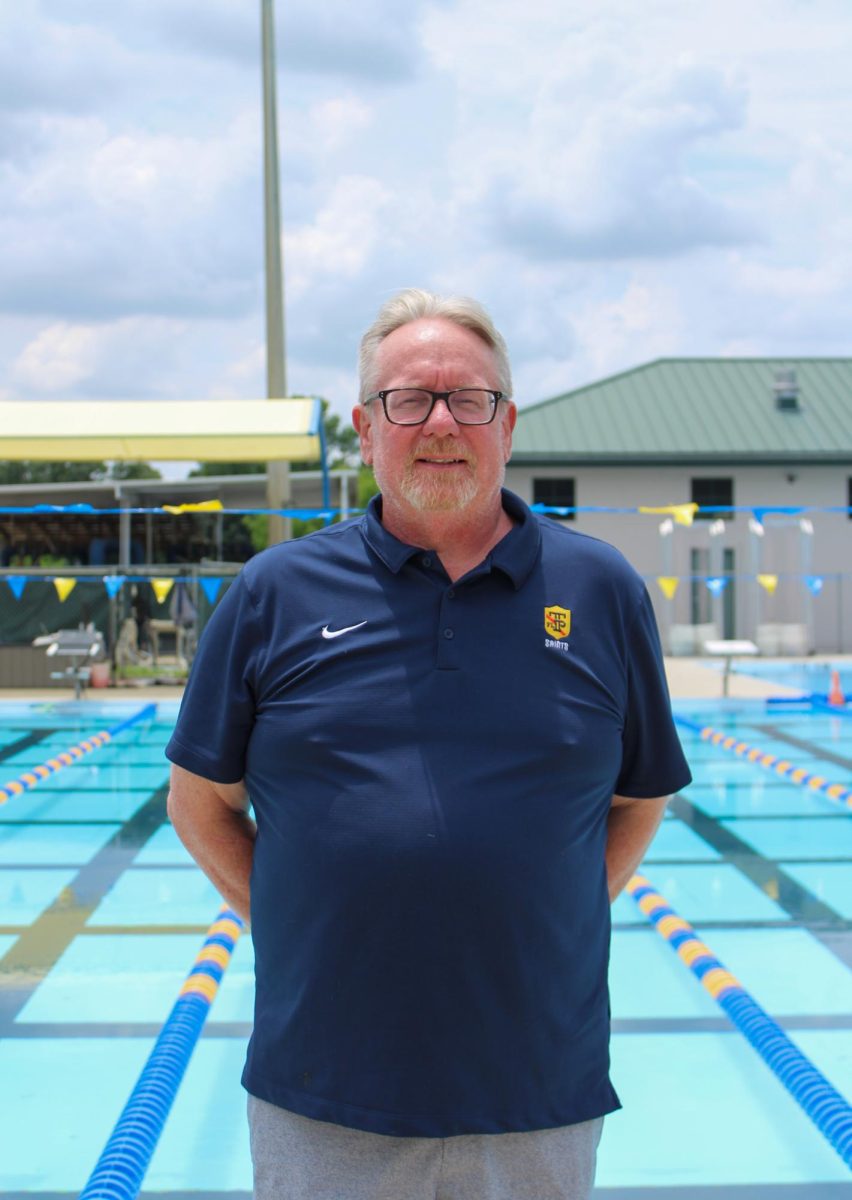 Corey Kephart poses by the pool deck, where he is making his debut as Trinity's new Aquatics Director and Head Swim Coach. 