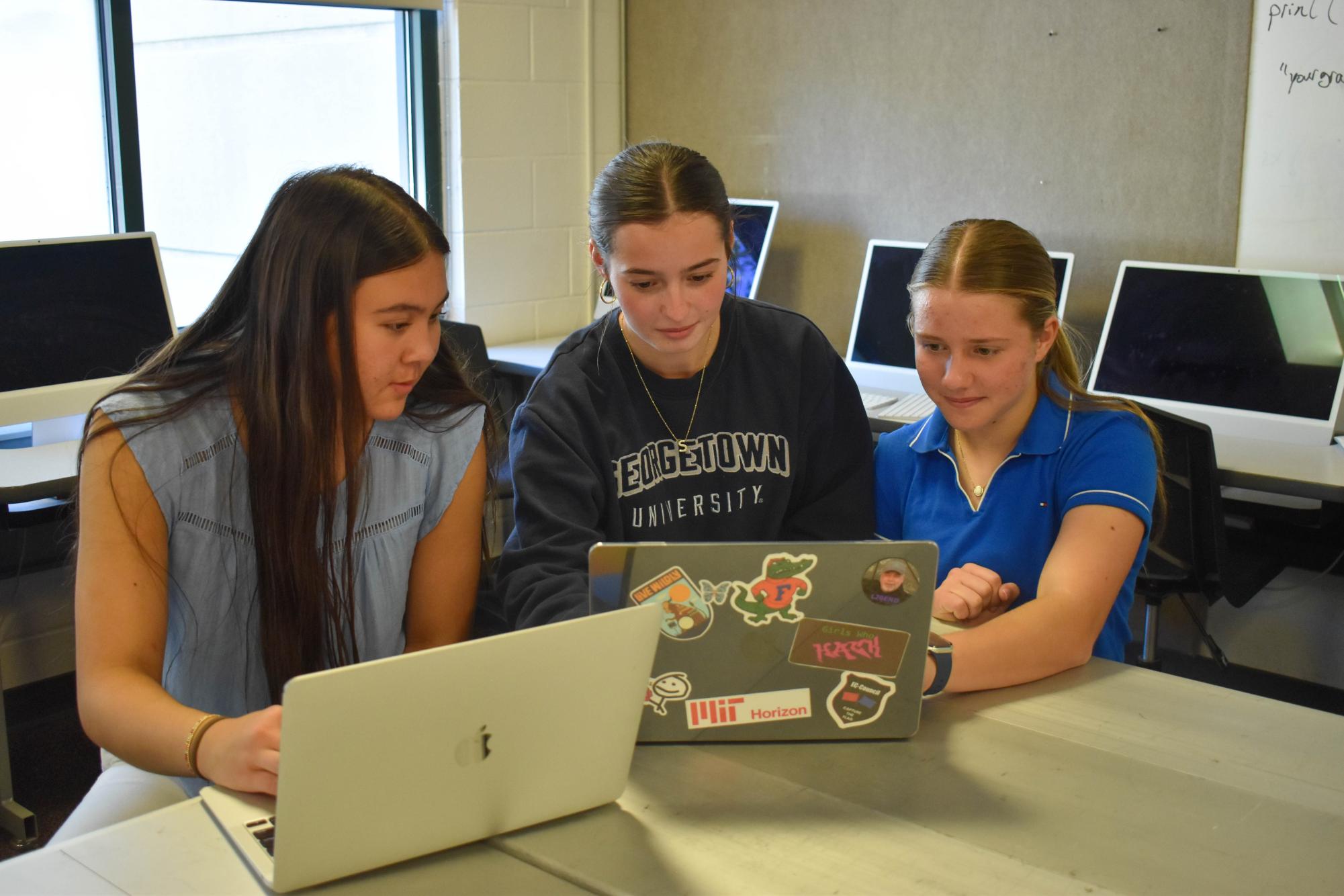 Members of the all-girls cybersecuity team practice coding on their laptops. Pictured from left to right is Sophie Yamada ‘27, Sarah Cantwell ‘26 and Grace Lohr ‘29.