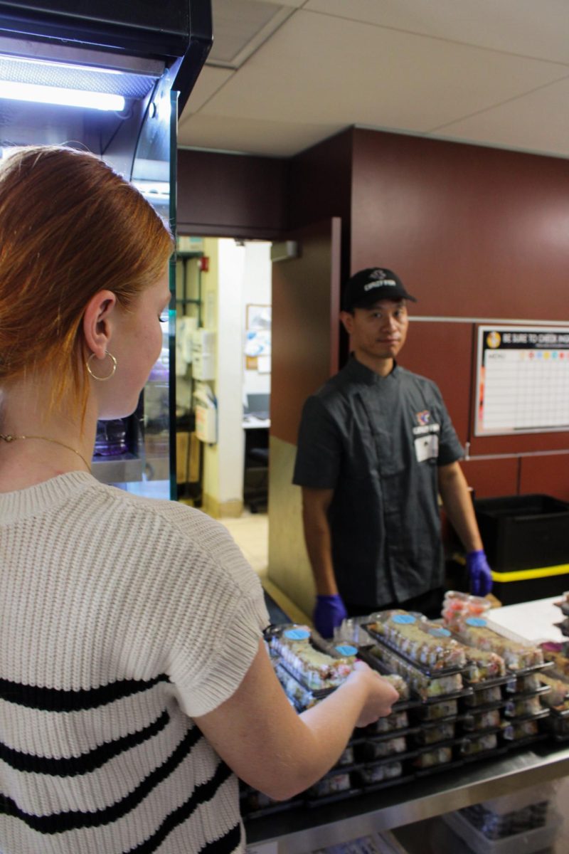 Senior Isabella Moore grabs a box of sushi from the Grille, which is a new item that comes with various options from crab to tuna.