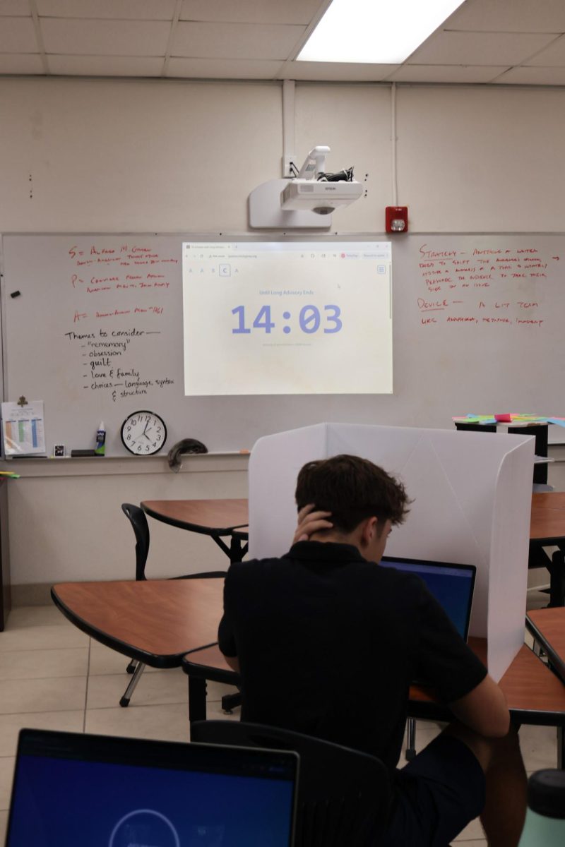 Junior Broc Williams works on his laptop as his teacher displays TPS Time on the board.
