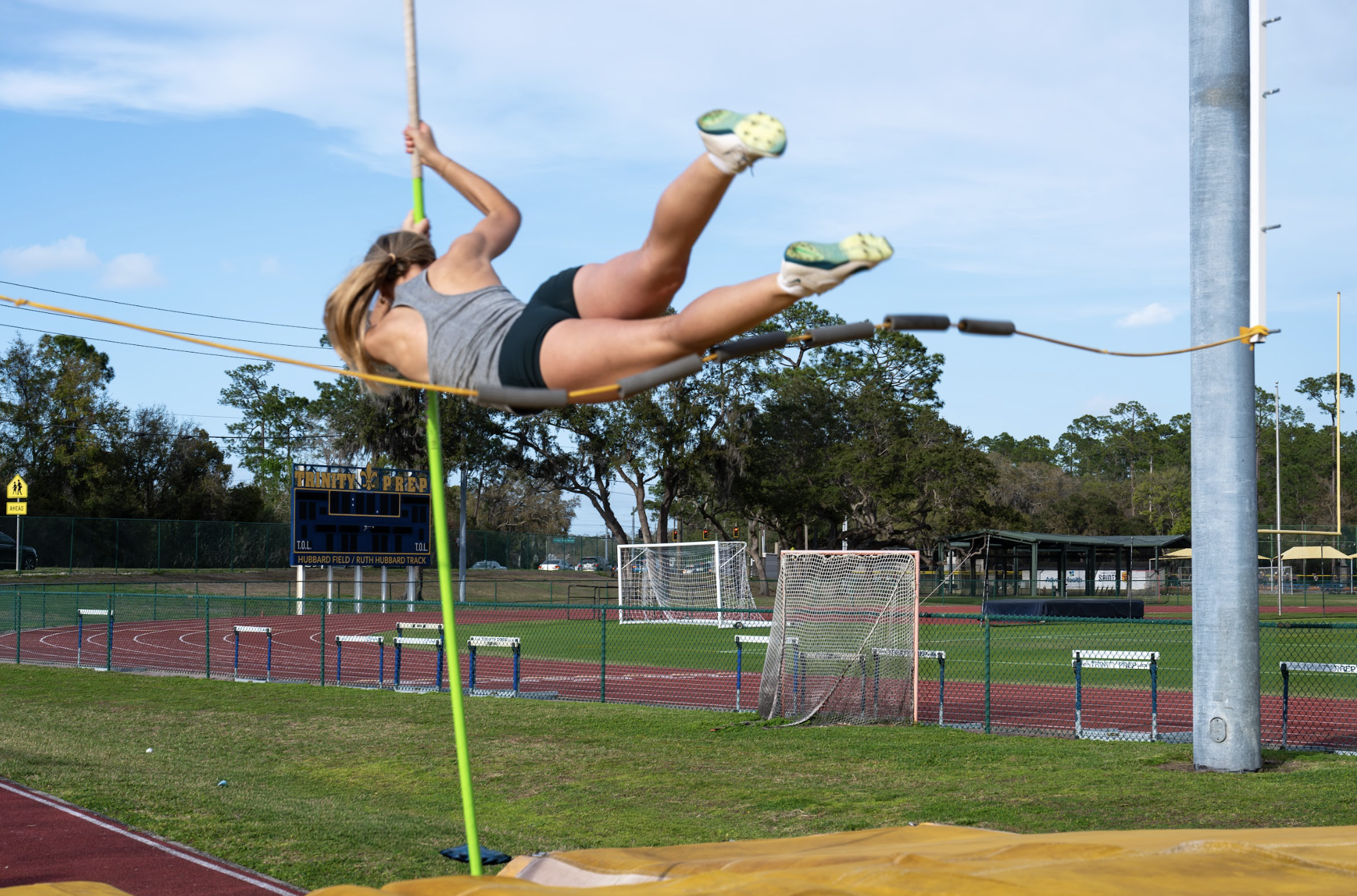 Senior Kelly Wentz, in her first year as a pole vaulter, soars over the bar during practice.
