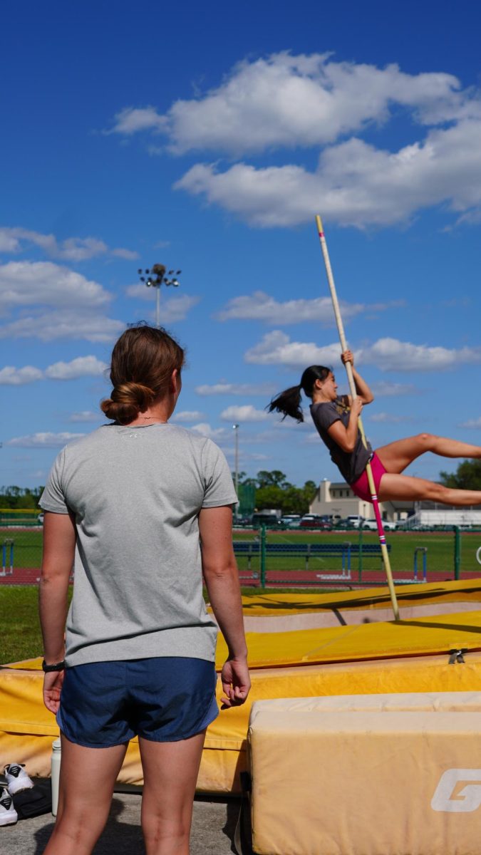 Kendra Payne coaches student on pole vaulting.