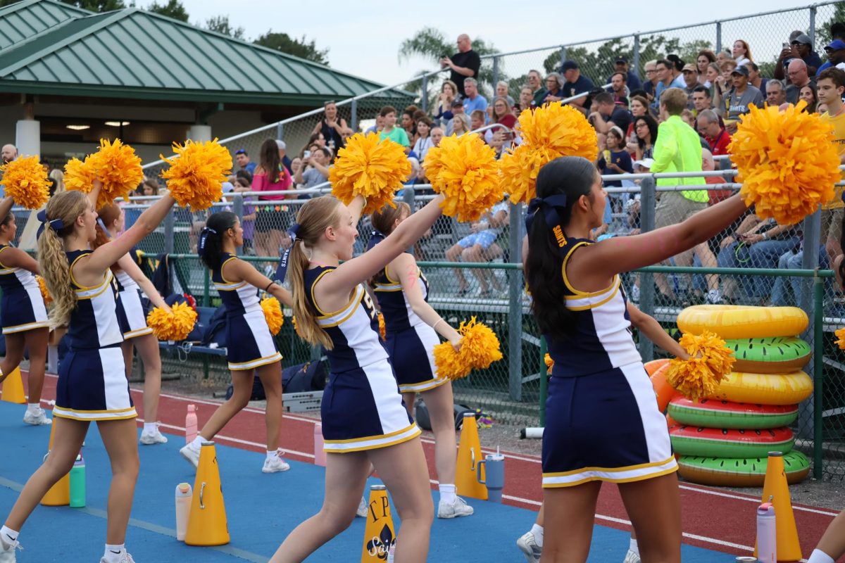 The varsity cheerleading team hypes up the crowd with various chants before and during a varsity football game.
